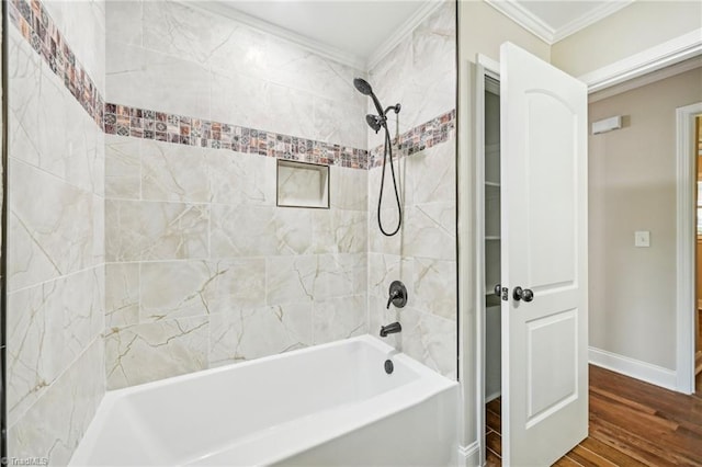 bathroom with crown molding, wood finished floors, shower / tub combination, and baseboards