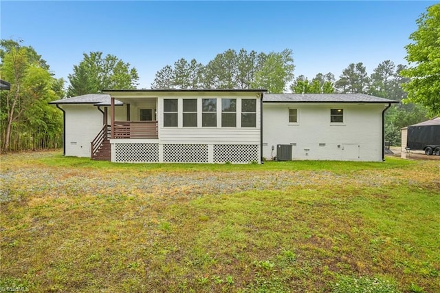 rear view of property with cooling unit, a lawn, and crawl space