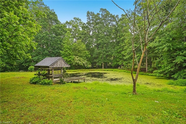 view of grassy yard with a forest view