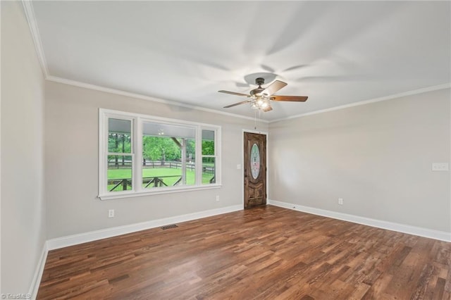 empty room with ceiling fan, wood finished floors, baseboards, and ornamental molding