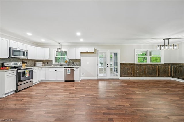 kitchen featuring appliances with stainless steel finishes, white cabinets, light countertops, tasteful backsplash, and recessed lighting