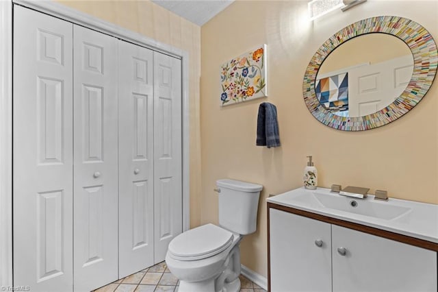 bathroom featuring tile patterned flooring, toilet, vanity, and a closet