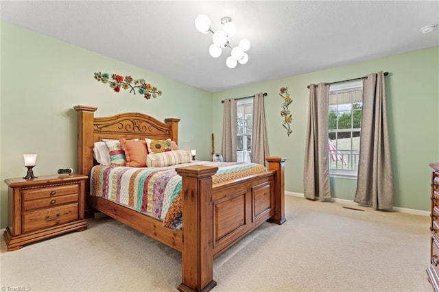 bedroom featuring a notable chandelier, baseboards, and light carpet