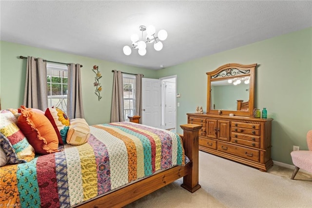 bedroom with a chandelier, a textured ceiling, baseboards, and carpet floors