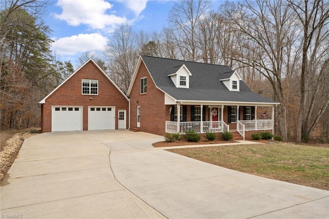 cape cod-style house with a porch, concrete driveway, brick siding, and a front lawn