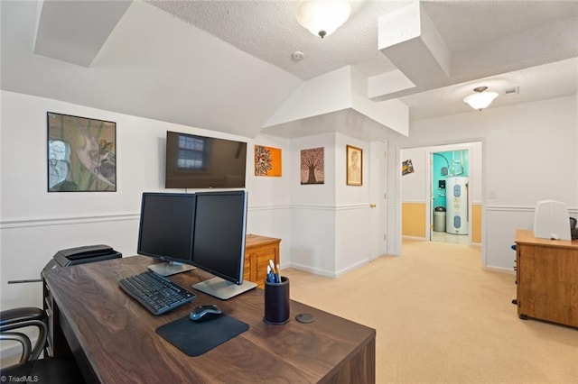 office space featuring baseboards, lofted ceiling, a textured ceiling, light colored carpet, and electric water heater