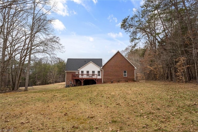 rear view of property featuring a lawn and a deck