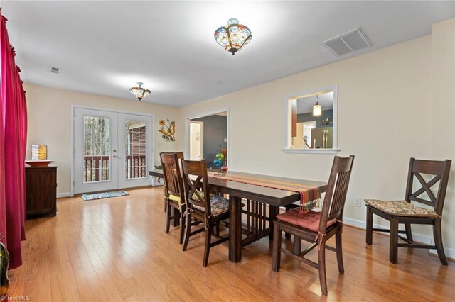 dining area featuring hardwood / wood-style flooring, french doors, visible vents, and baseboards