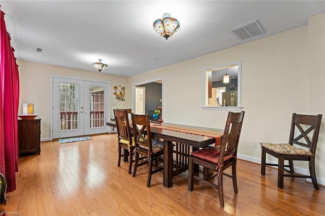 dining room featuring visible vents, wood-type flooring, baseboards, and french doors