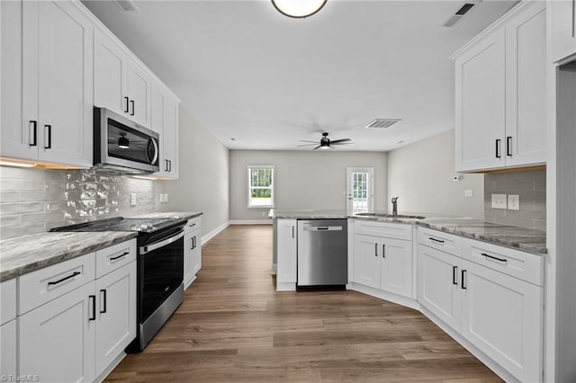 1337 Union Cross Rd, Kernersville, NC 27284 - kitchen with stainless steel appliances, a peninsula, ceiling fan, light wood-style flooring, and white cabinetry
