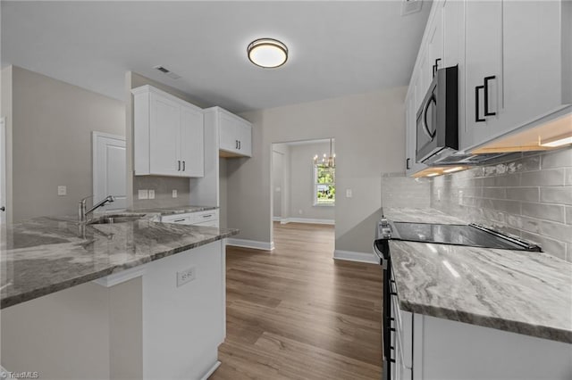 1337 Union Cross Rd, Kernersville, NC 27284 - kitchen with stainless steel microwave, range with electric cooktop, light stone countertops, and white cabinets