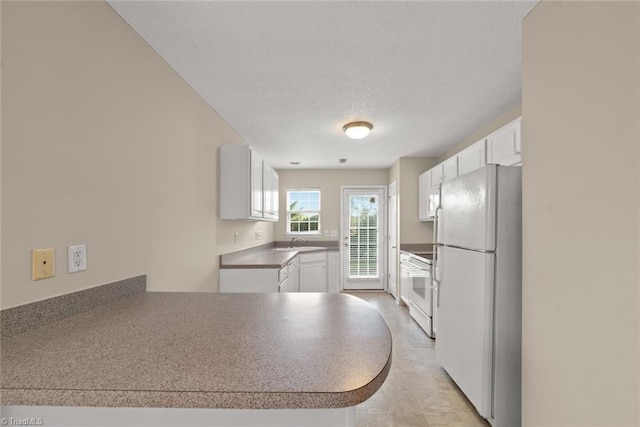 kitchen with kitchen peninsula, sink, white cabinets, a textured ceiling, and white appliances