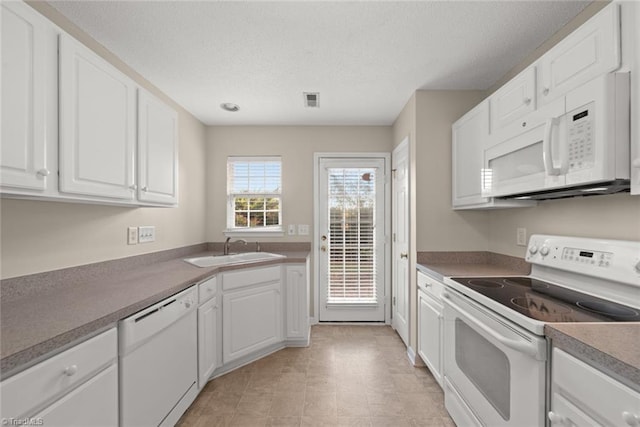 kitchen with white cabinets, sink, and white appliances