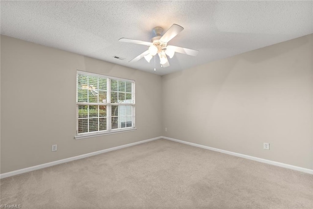 carpeted empty room featuring ceiling fan and a textured ceiling