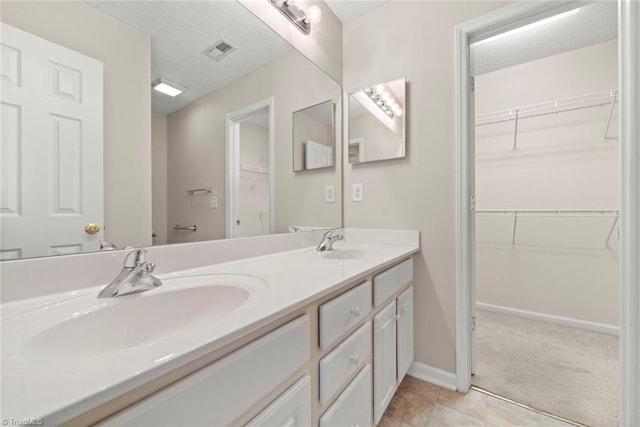 bathroom with vanity, a textured ceiling, and tile patterned floors