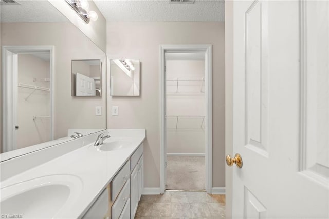 bathroom featuring vanity, tile patterned floors, and a textured ceiling