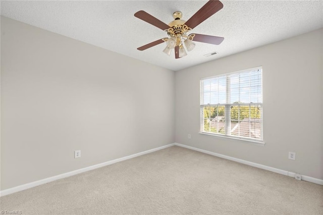 spare room with ceiling fan, carpet, and a textured ceiling