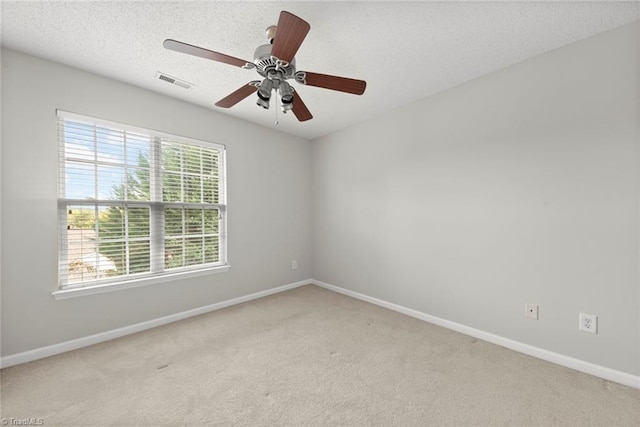 spare room with light carpet, a textured ceiling, and ceiling fan