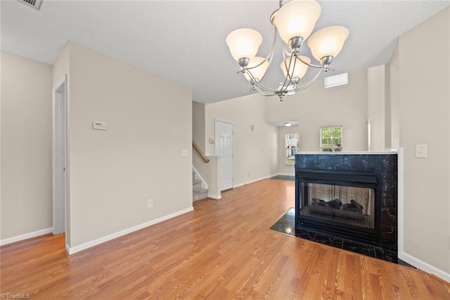 living room featuring a multi sided fireplace, a chandelier, and wood-type flooring