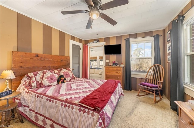 carpeted bedroom featuring ceiling fan and crown molding