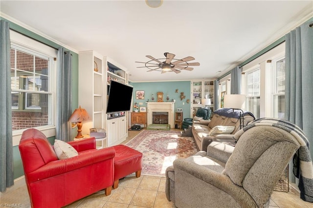 living room with light tile patterned floors, ceiling fan, and ornamental molding