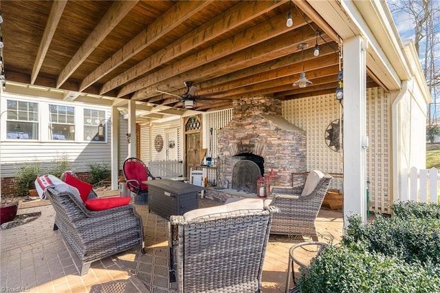 view of patio / terrace featuring ceiling fan and an outdoor living space with a fireplace