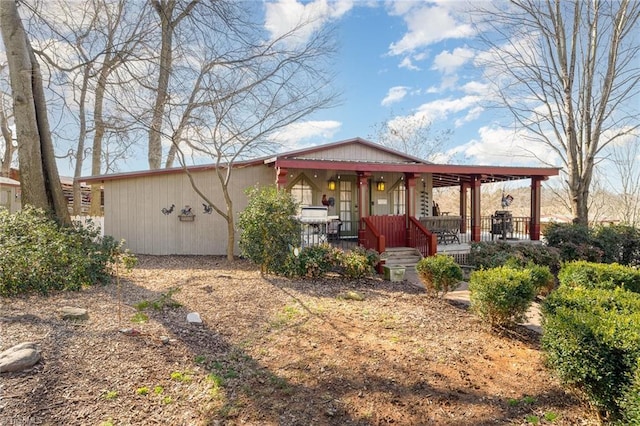 rear view of property featuring covered porch