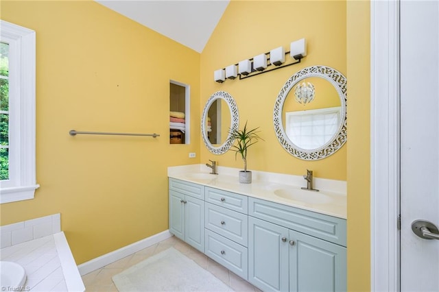 183 Scottsdale Dr, Advance, NC 27006 - bathroom with double vanity, lofted ceiling, a bath, baseboards, and tile patterned flooring