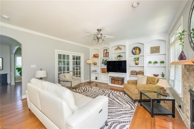 183 Scottsdale Dr, Advance, NC 27006 - living room with a stone fireplace, ceiling fan, arched walkways, wood finished floors, and ornamental molding