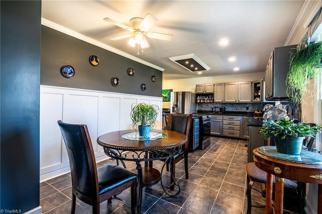 dining space with ceiling fan, crown molding, and dark tile patterned floors