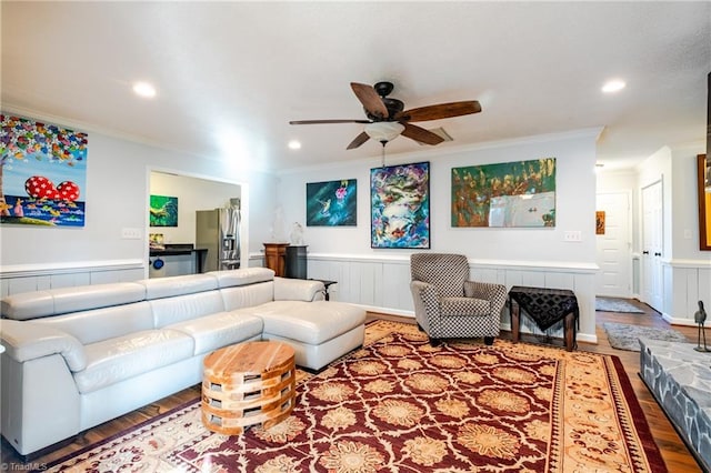 living room with hardwood / wood-style floors, ornamental molding, and ceiling fan