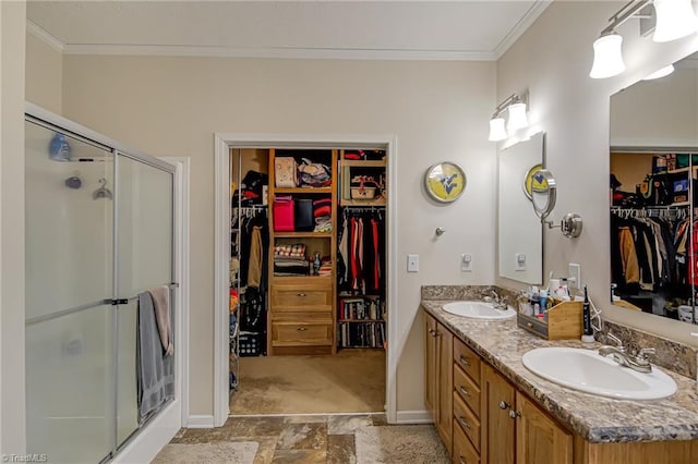 bathroom featuring ornamental molding, a stall shower, and a sink