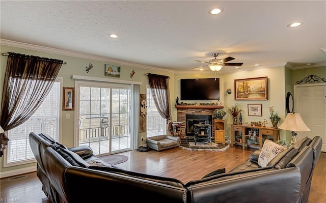 living area featuring ceiling fan, a healthy amount of sunlight, crown molding, and wood finished floors