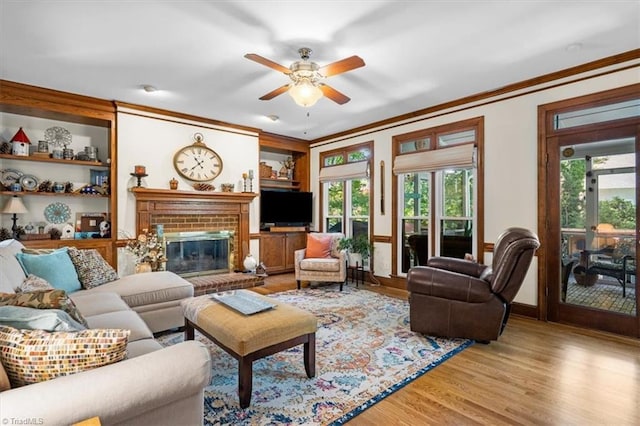 4802 Worchester Pl, Jamestown, NC 27282 - living room featuring crown molding, a fireplace, light wood-type flooring, and ceiling fan