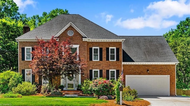 4802 Worchester Pl, Jamestown, NC 27282 - georgian-style home featuring brick siding, an attached garage, a chimney, and driveway