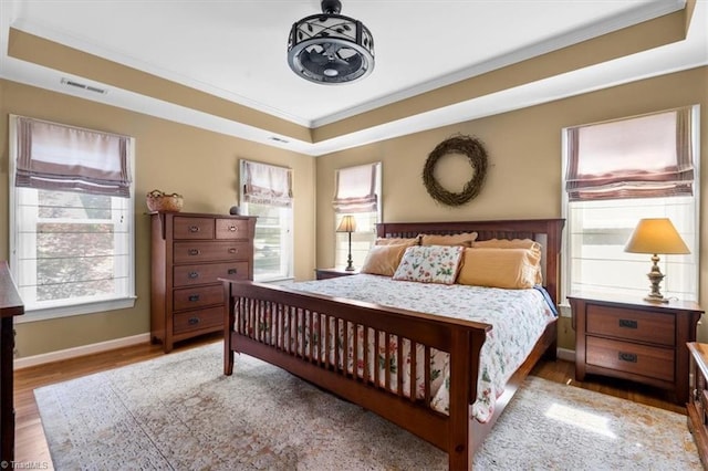 4802 Worchester Pl, Jamestown, NC 27282 - bedroom with a raised ceiling, multiple windows, wood finished floors, ornamental molding, and baseboards