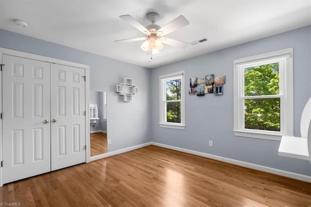 4802 Worchester Pl, Jamestown, NC 27282 - unfurnished bedroom featuring multiple windows, wood finished floors, and baseboards