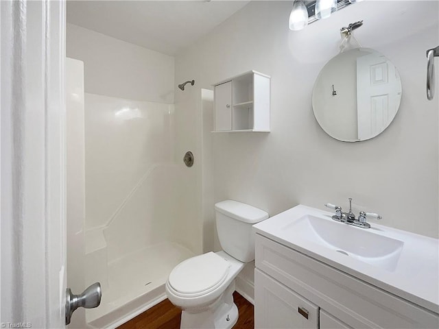 bathroom featuring vanity, wood finished floors, walk in shower, and toilet