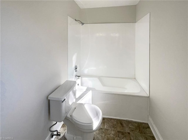 bathroom featuring toilet, baseboards, and tub / shower combination