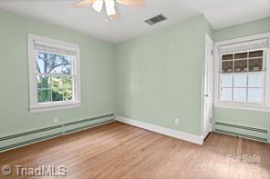 720 Ferndale Blvd, High Point, NC 27262 - unfurnished room featuring wood finished floors, a baseboard radiator, a ceiling fan, and baseboards