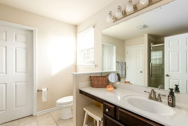 bathroom with tile patterned floors, vanity, toilet, and a shower with door