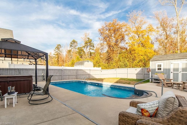 view of pool with a gazebo, a shed, a hot tub, and a patio area