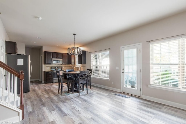 dining space with an inviting chandelier and light hardwood / wood-style flooring