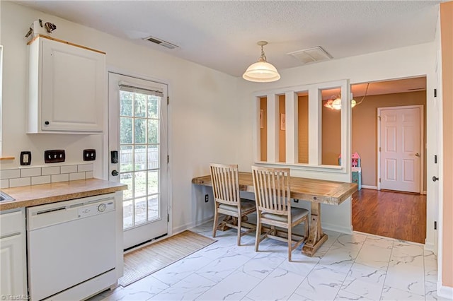 dining area with a wealth of natural light, visible vents, and marble finish floor