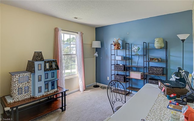 carpeted office featuring visible vents, baseboards, and a textured ceiling