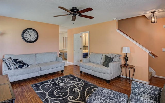 living room featuring ceiling fan, stairway, baseboards, and wood finished floors