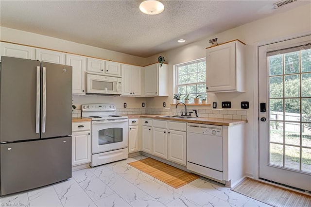 kitchen featuring a sink, white appliances, marble finish floor, and white cabinets