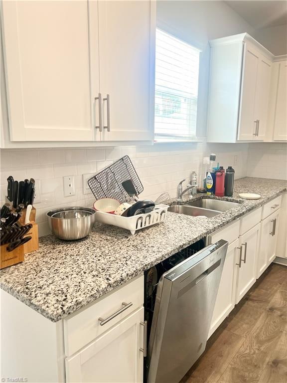 kitchen with backsplash, white cabinets, sink, stainless steel dishwasher, and dark hardwood / wood-style floors