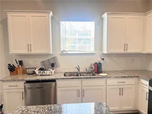 kitchen with dishwasher, sink, tasteful backsplash, light stone counters, and white cabinets