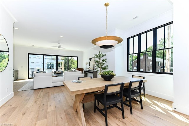 dining room featuring light wood finished floors, crown molding, baseboards, and recessed lighting